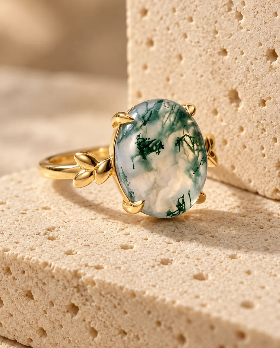Oval Moss Agate Ring - displayed on a travertine block