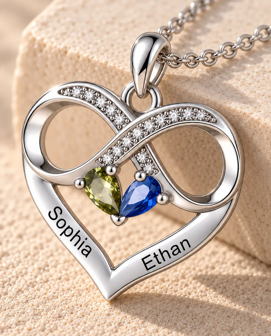 Close-up of the infinity heart pendant with two pear birthstones and two engraved names