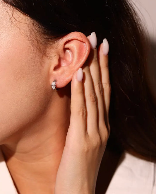 Moissanite Hoop Earrings in 925 Sterling Silver - worn on a model’s ear, hand near her face