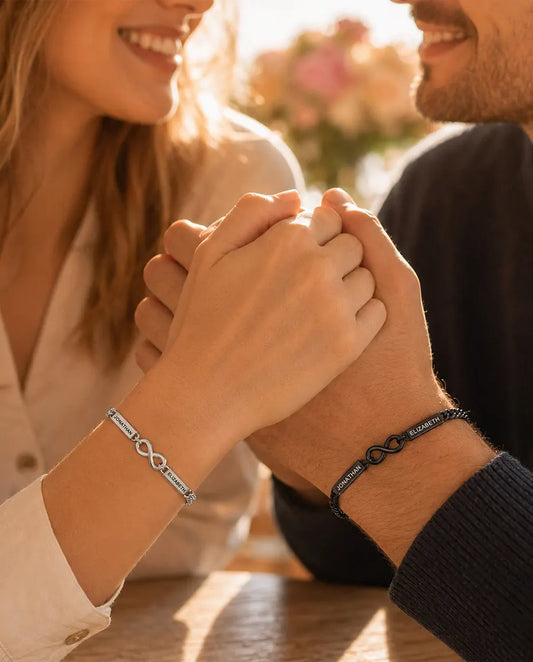 Personalized Infinity Couple Bracelets With 2 Engraved Names - Matching Silver & Black Name Bar Bracelet Set - worn by a couple holding hands