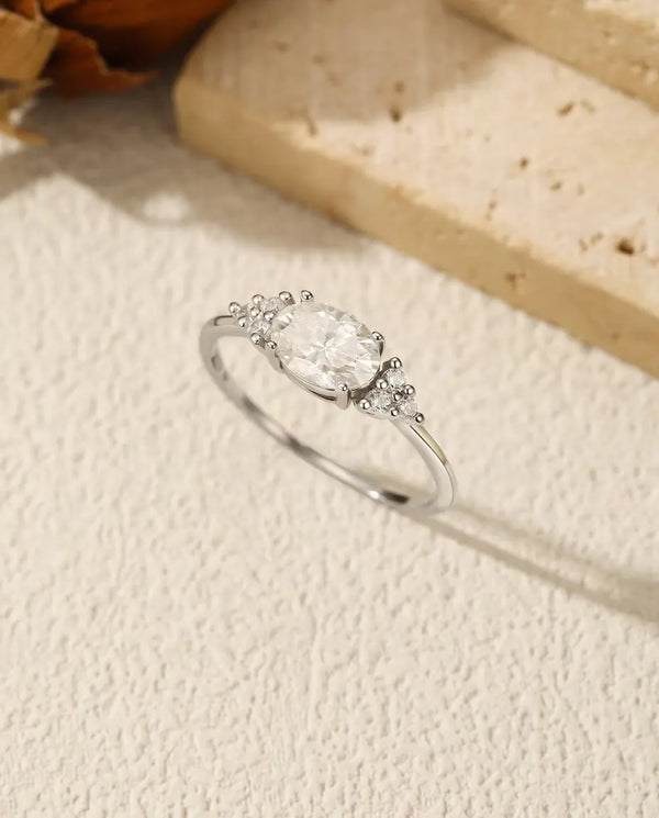 1 carat oval moissanite engagement ring in 925 sterling silver with zirconia side clusters