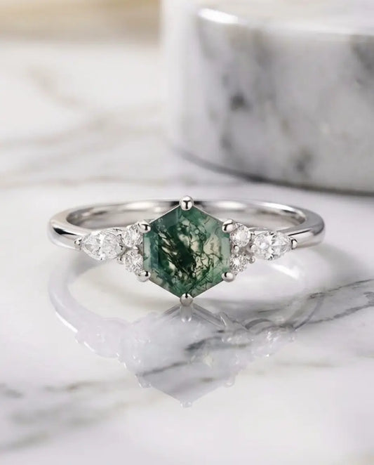 Kite-cut moss agate ring set in gold-plated sterling silver shown beside green moss agate stones