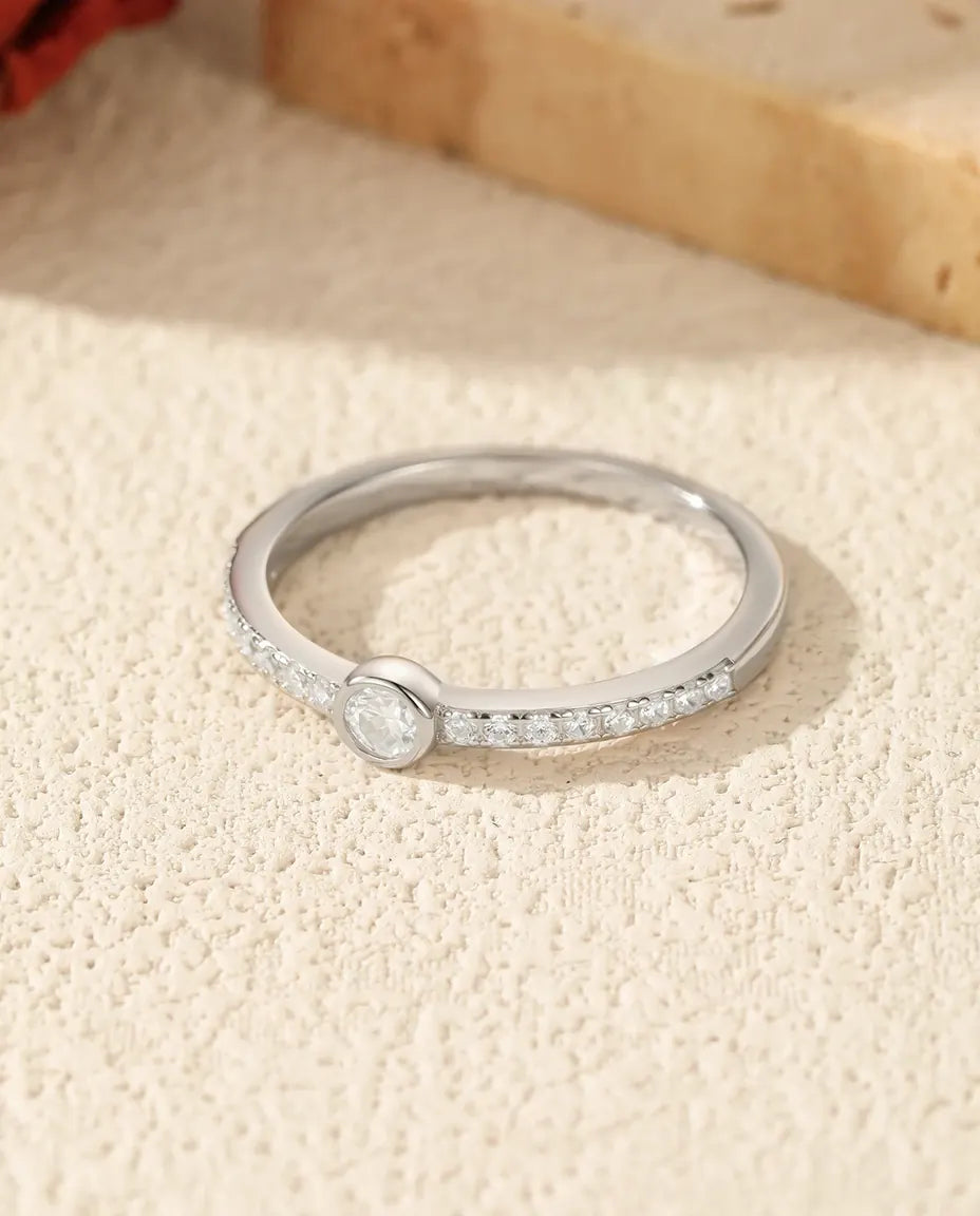 Bezel-set moissanite solitaire ring in 925 sterling silver with pave shoulders