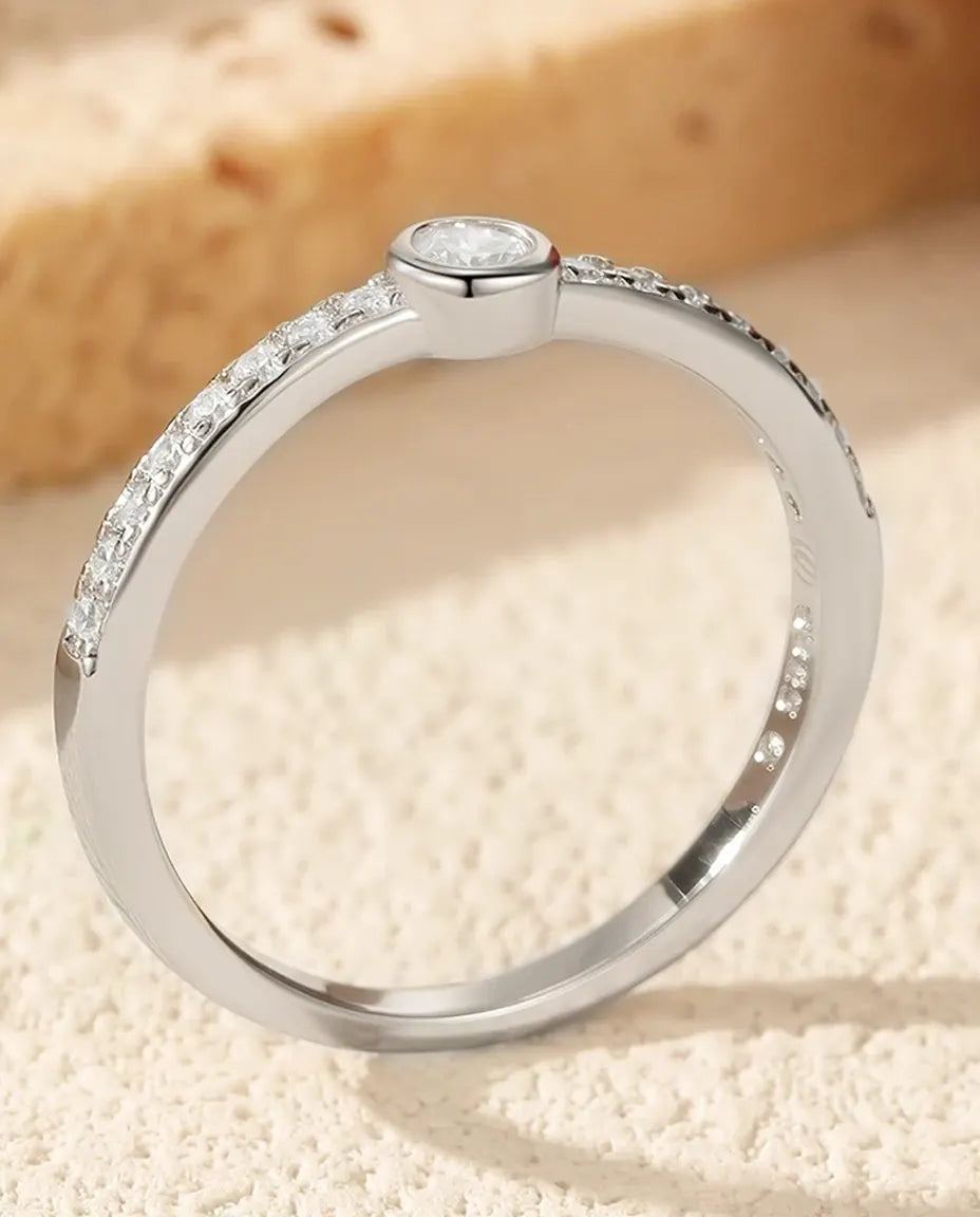 Bezel-set moissanite solitaire ring in 925 sterling silver with pave shoulders