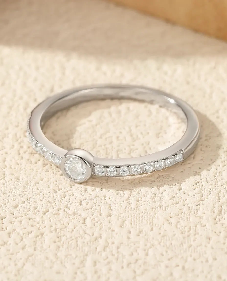 Bezel-set moissanite solitaire ring in 925 sterling silver with pave shoulders
