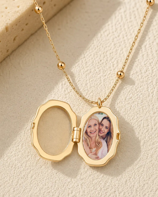 Gold butterfly photo locket opened to show one oval picture of a mother and daughter inside