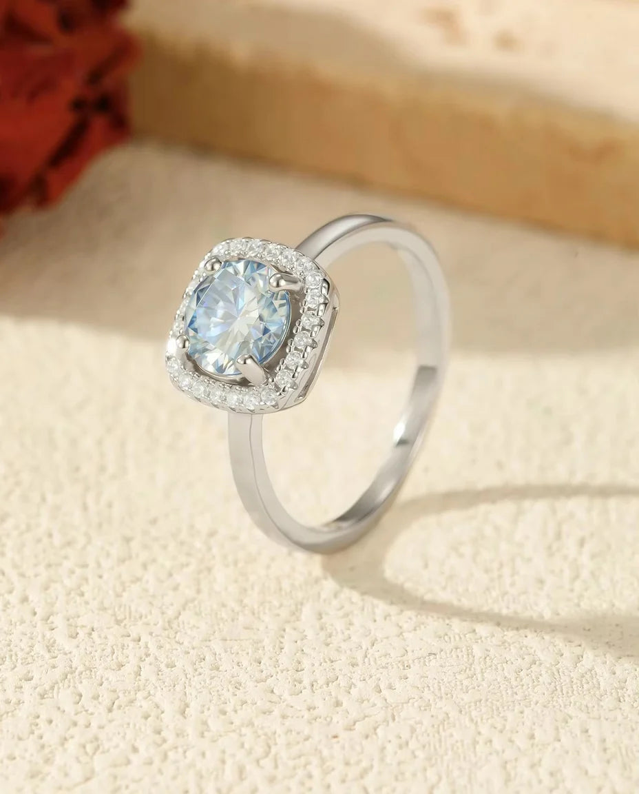 Sea Blue Moissanite Ring - displayed on a travertine block