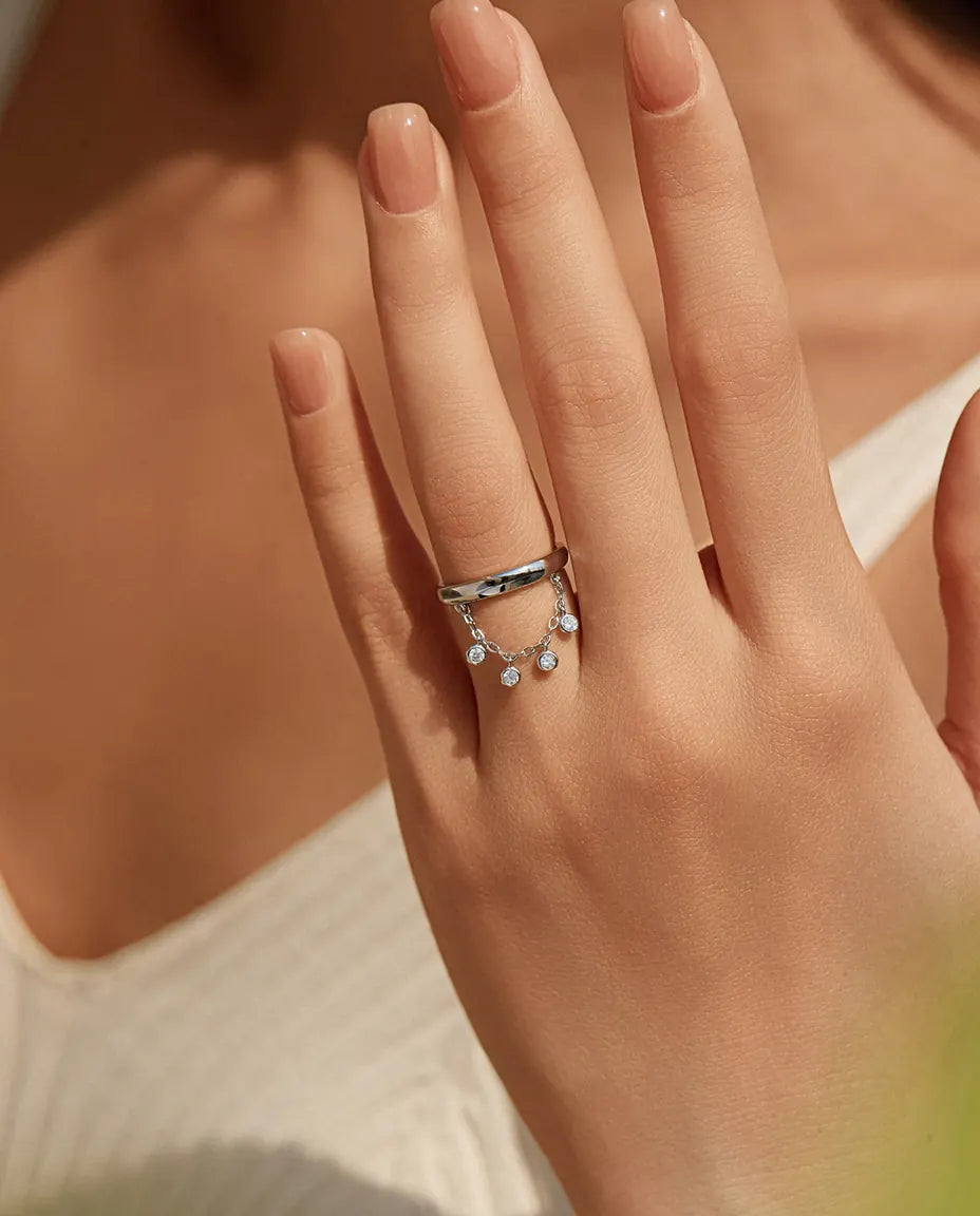 Sterling silver charm ring with draped chain and bezel set cubic zirconia drops