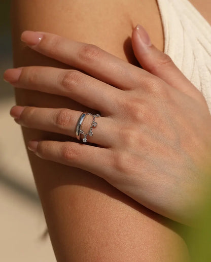 Sterling silver charm ring with draped chain and bezel set cubic zirconia drops