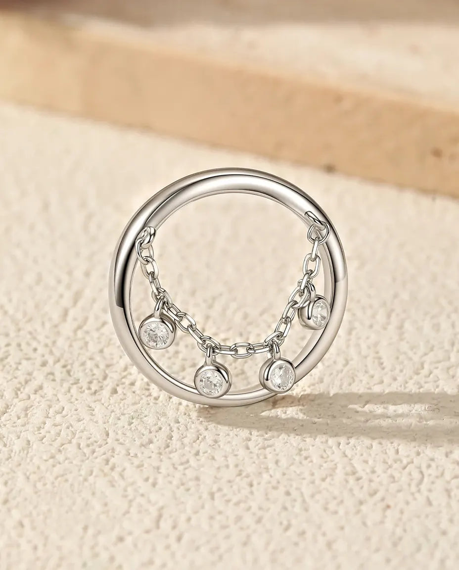 Sterling silver charm ring with draped chain and bezel set cubic zirconia drops