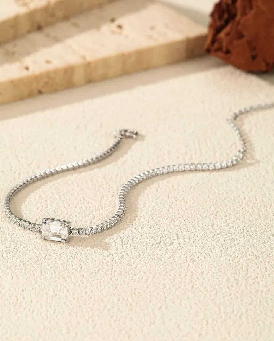 Tennis bracelet with a 1ct D color emerald cut moissanite center stone and cubic zirconia side stones, 925 sterling silver