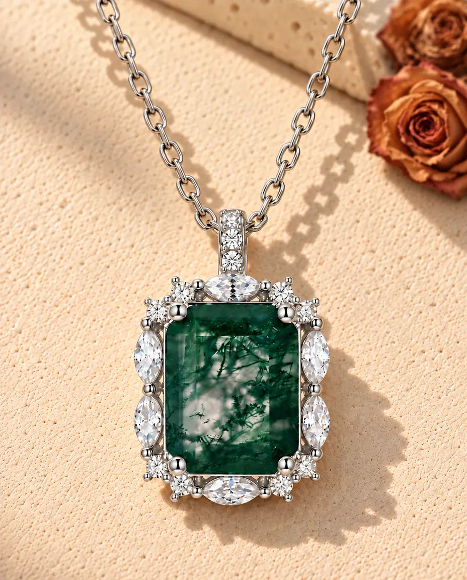 Emerald Cut Moss Agate Cluster Necklace in 925 Sterling Silver - lying on a cream textured surface beside a travertine block