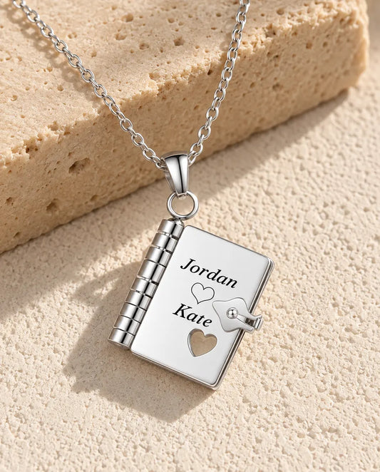 Personalized book locket necklace in silver stainless steel, front cover engraved with two names and a heart