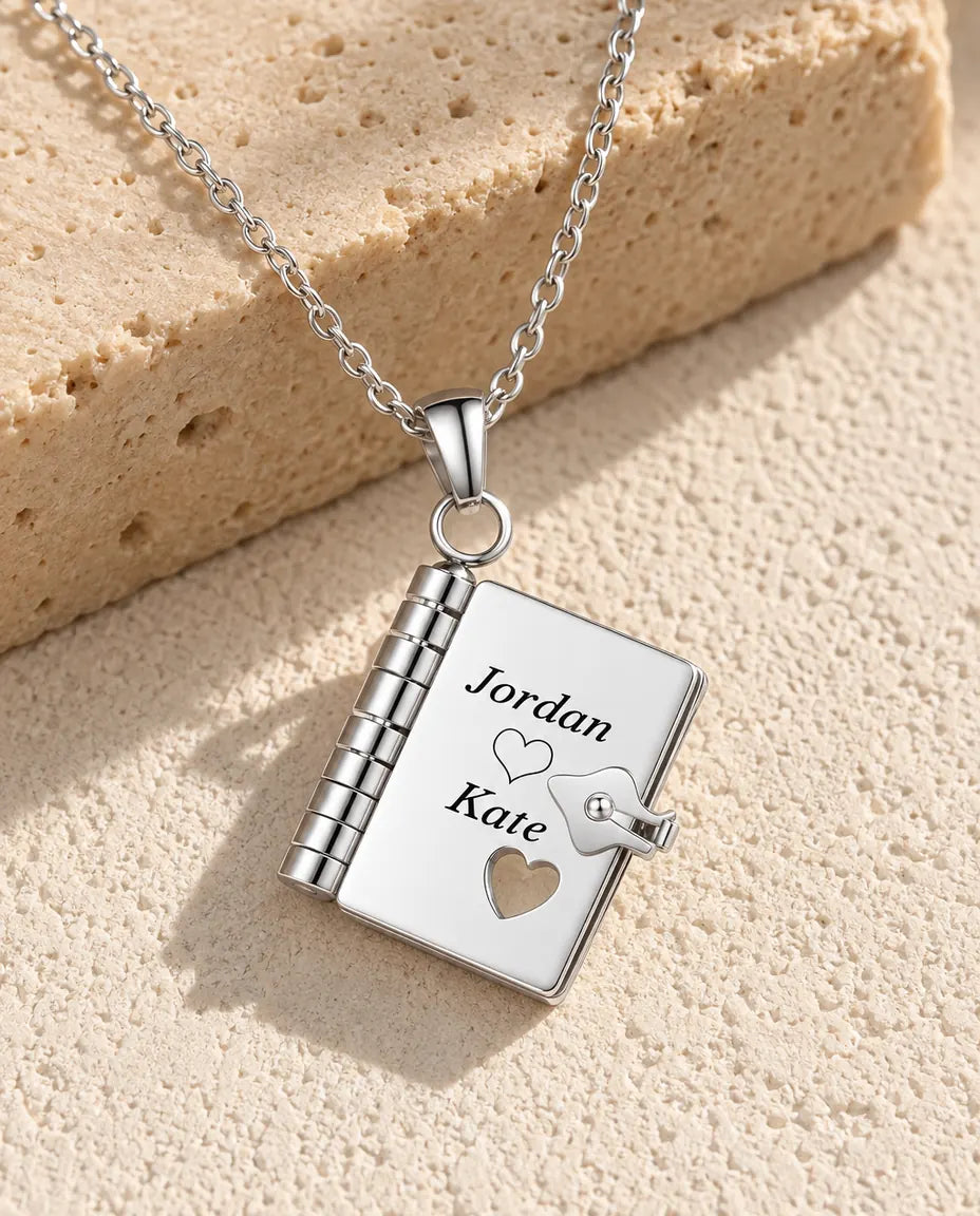 Personalized book locket necklace in silver stainless steel, front cover engraved with two names and a heart