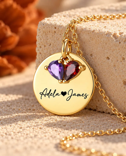 Gold disc name necklace photographed from a low angle