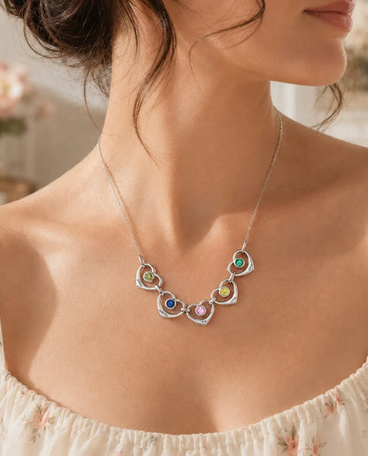 Woman wearing the family birthstone necklace with linked hearts