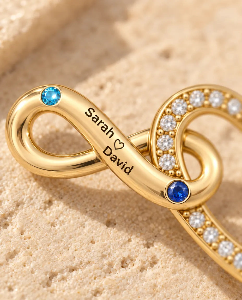 Macro detail of the engraved names and the birthstones on the infinity band