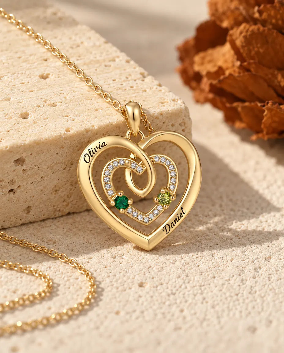 Gold triple heart name necklace photographed from a low angle