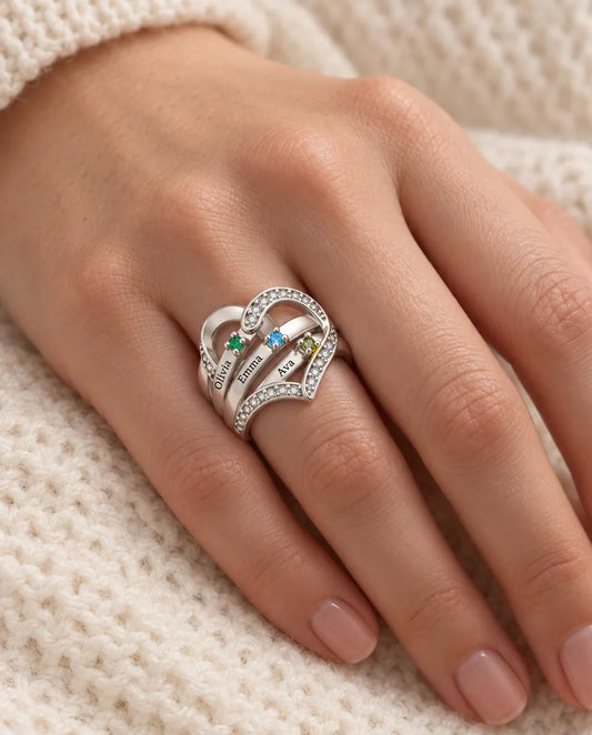 woman wearing personalized heart birthstone ring with 3 engraved names on her ring finger