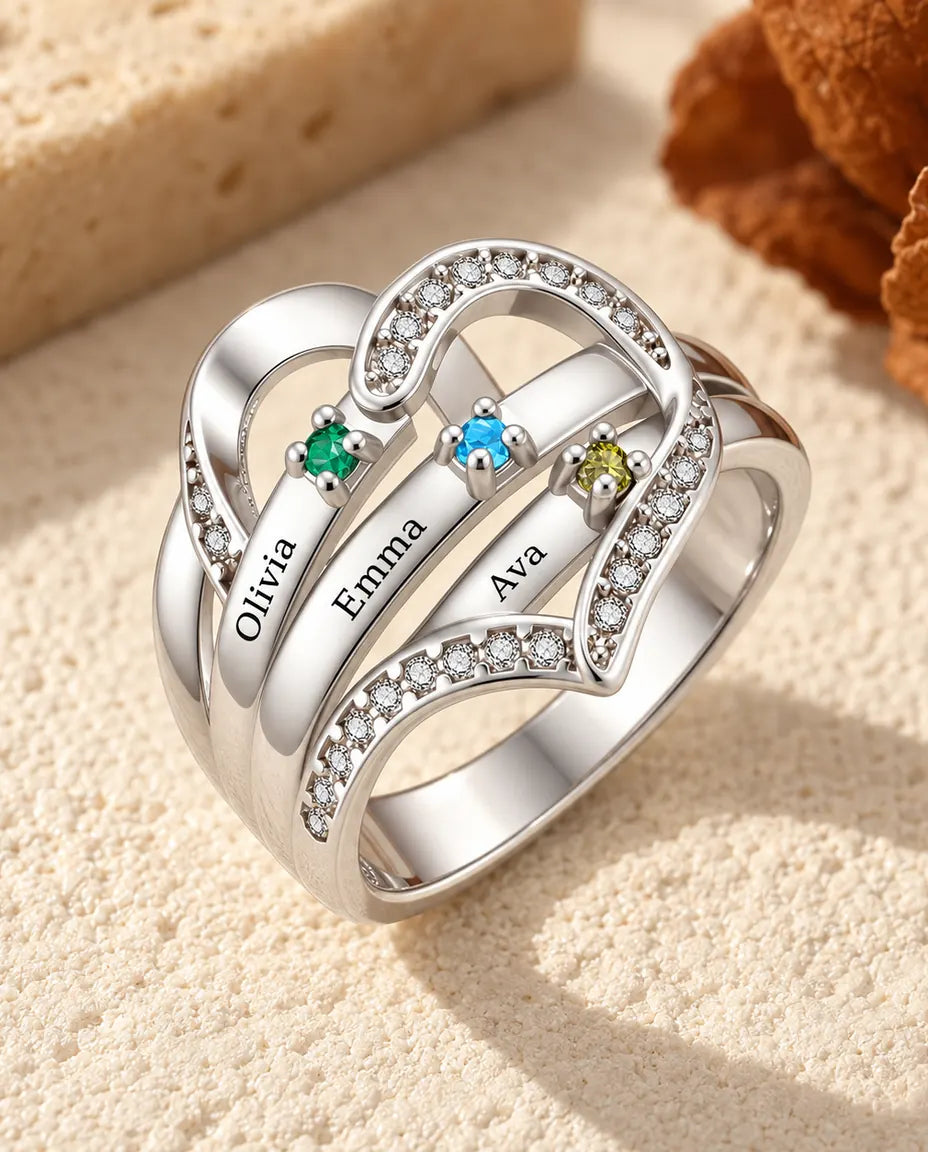 close up of the heart birthstone ring showing the four prong settings and the engraved names