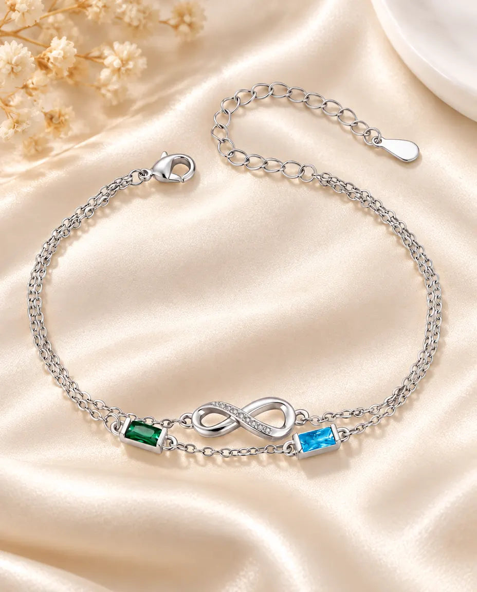 Personalized infinity birthstone bracelet with two baguette birthstones on a double silver chain