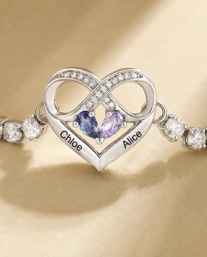 Close-up of the infinity heart charm with two pear birthstones and two engraved names