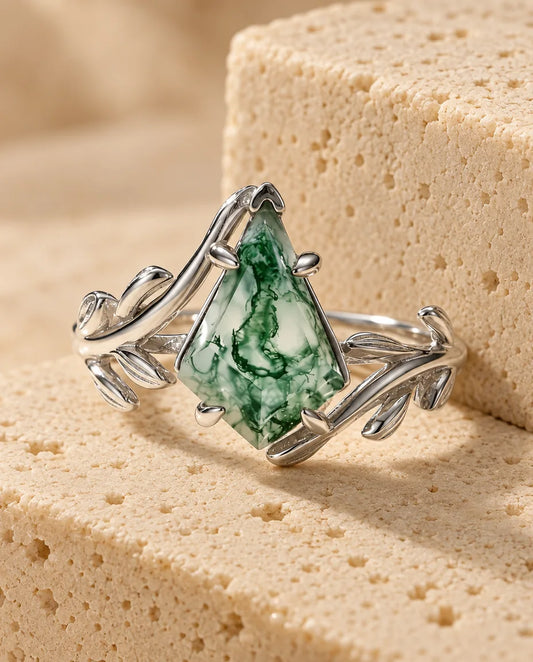 Kite-Cut Moss Agate Leaf Ring in Sterling Silver - displayed on a travertine block