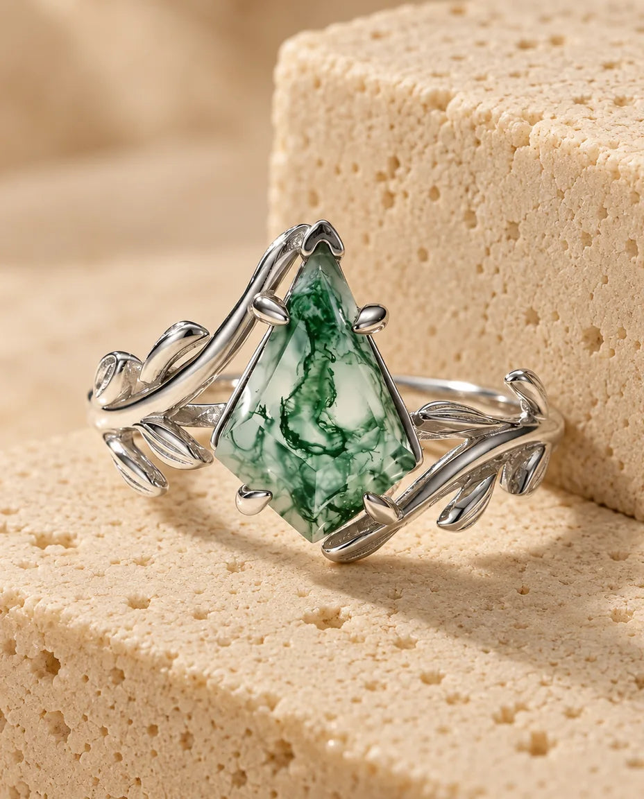 Kite-Cut Moss Agate Leaf Ring in Sterling Silver - displayed on a travertine block