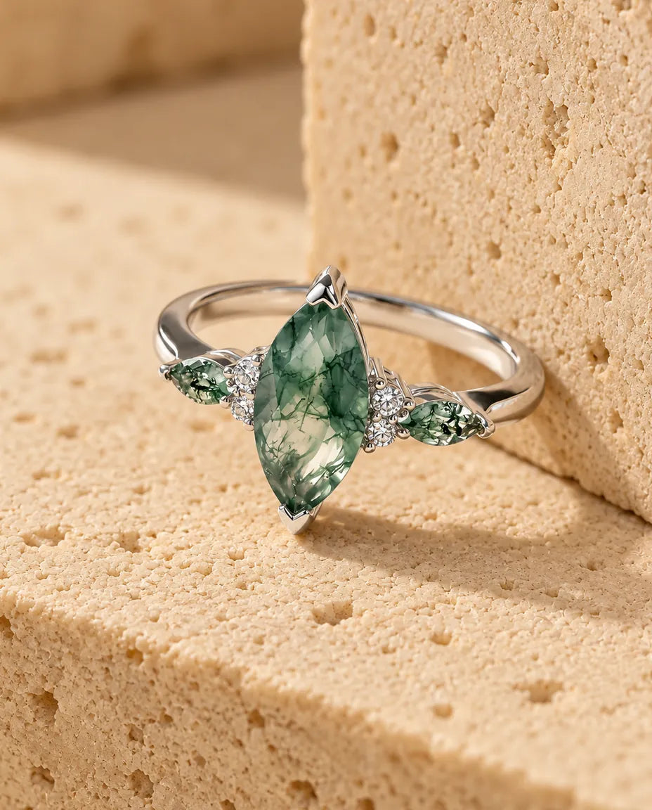Marquise Moss Agate Ring - displayed on a travertine block