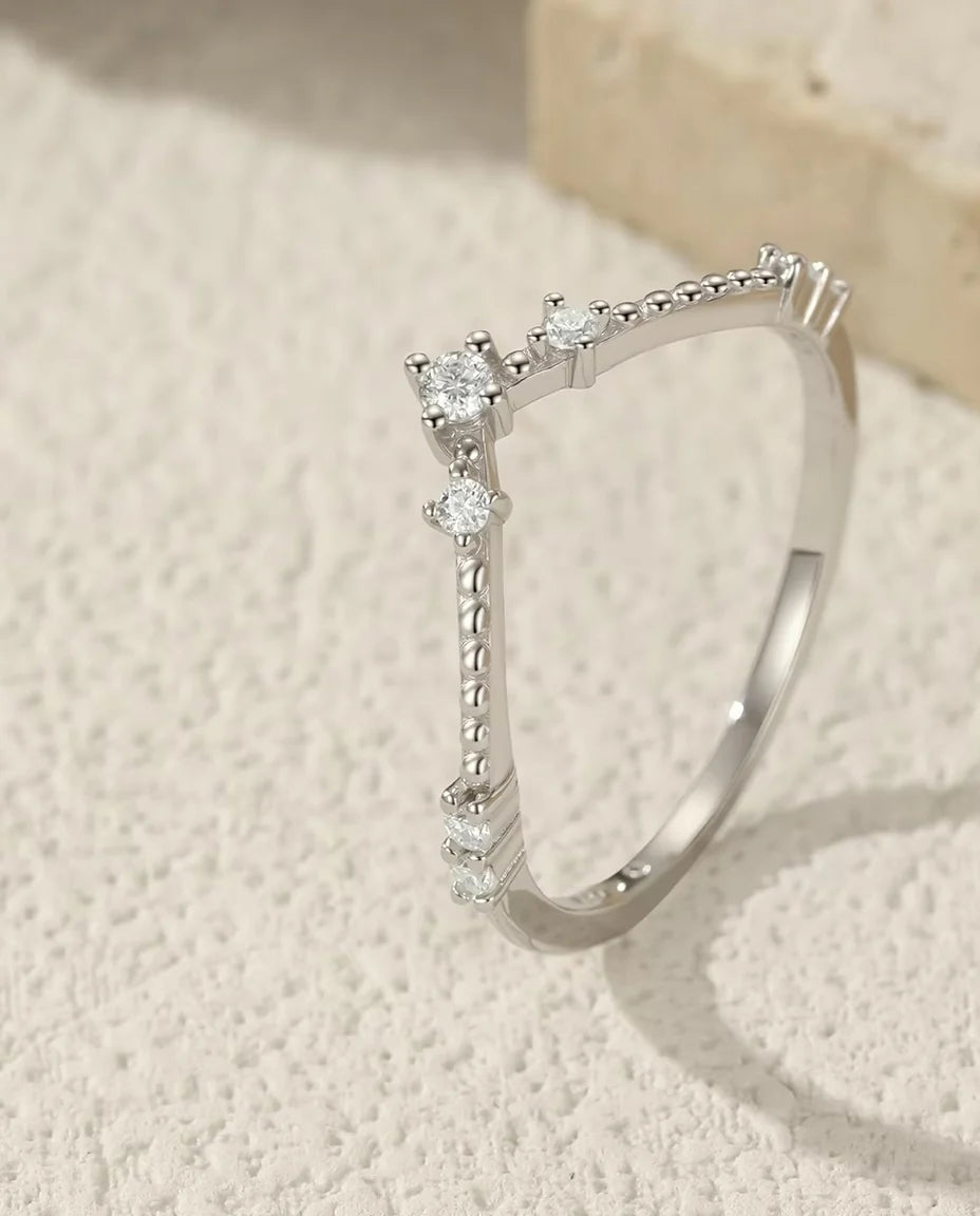 Sterling Silver Moissanite Wedding Band Ring - displayed on a travertine block