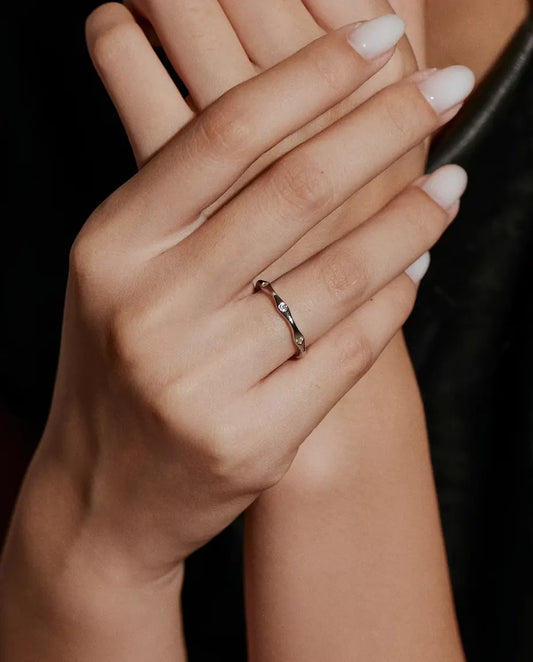 Moissanite Wave Ring in 925 Sterling Silver - worn on a raised hand