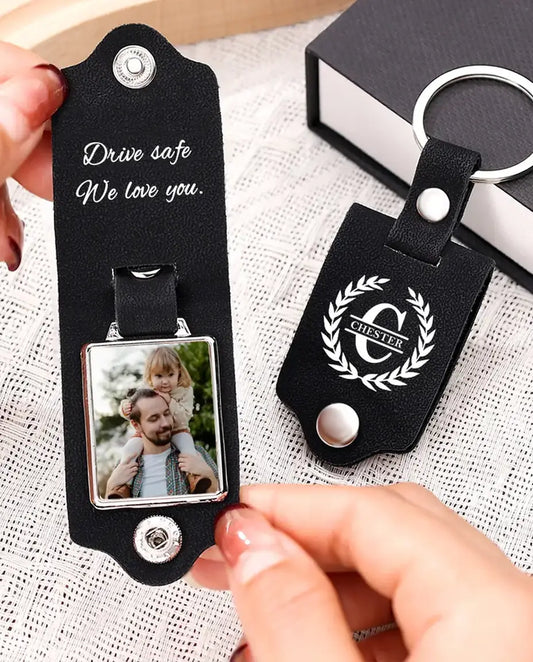 Hands opening the black faux leather keychain to show the photo inside