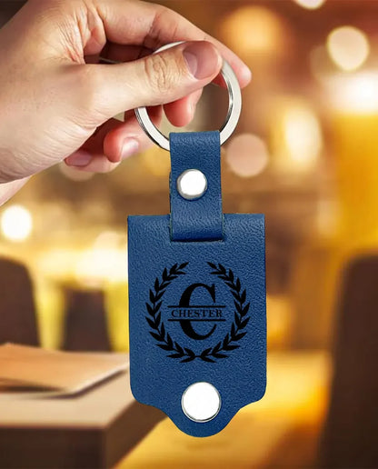 Hand holding the blue faux leather monogram photo keychain