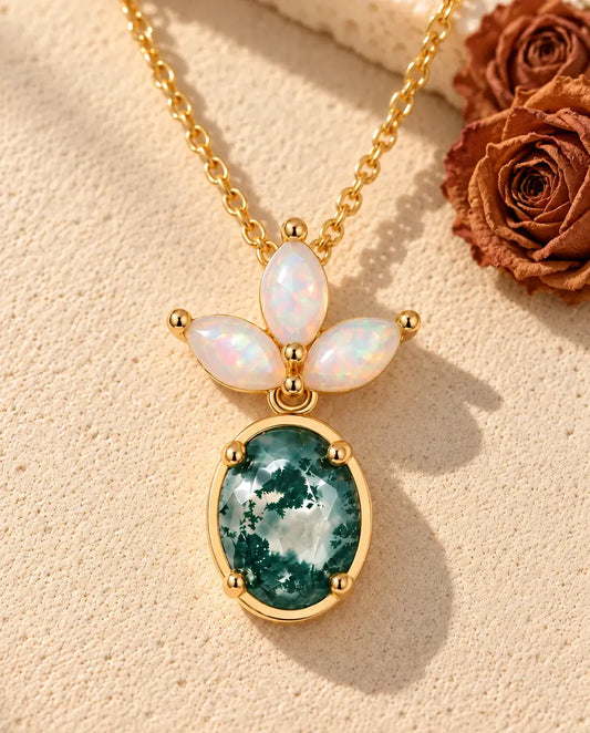 Moss Agate and Opal Drop Necklace in Gold Plated 925 Sterling Silver - lying on a cream textured surface beside a travertine block