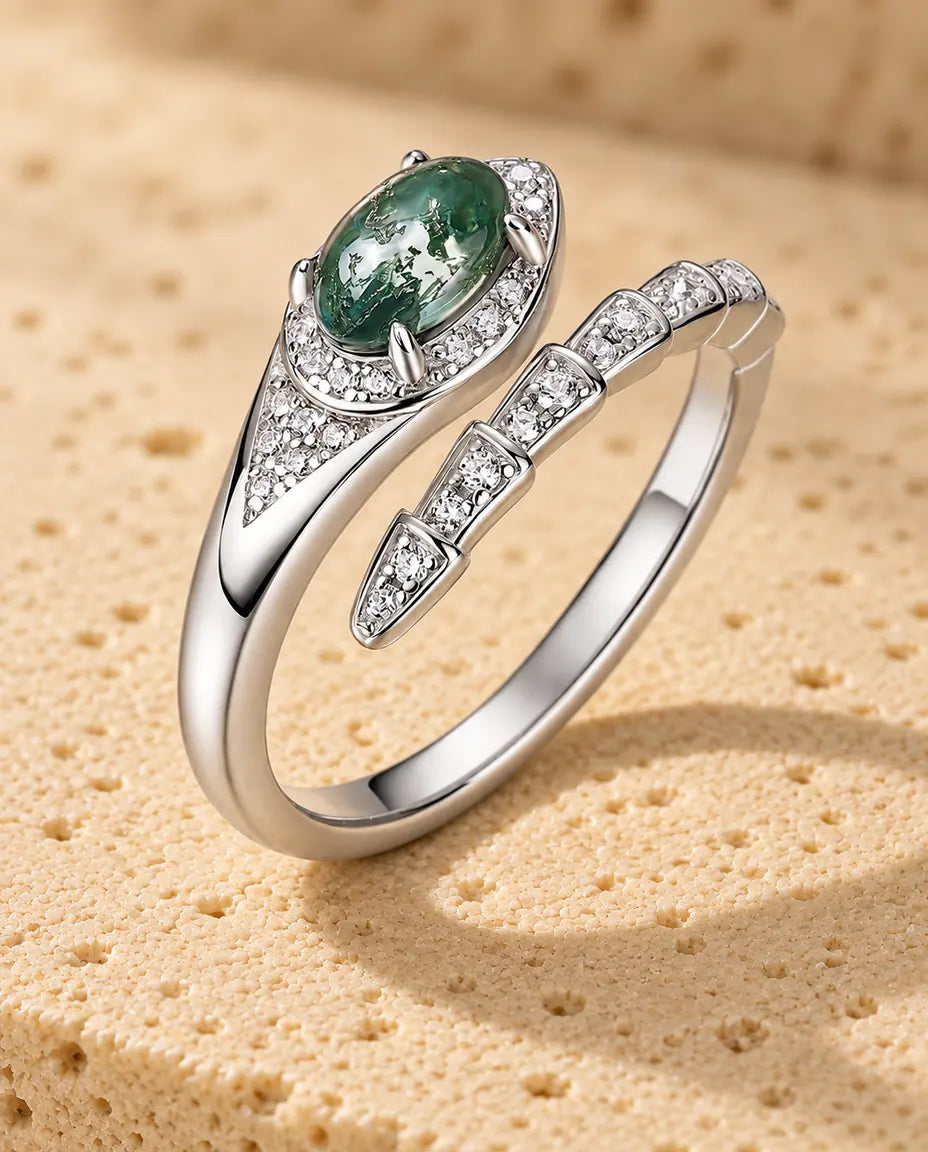 Moss Agate Snake Ring in 925 Sterling Silver - standing upright on a cream textured surface