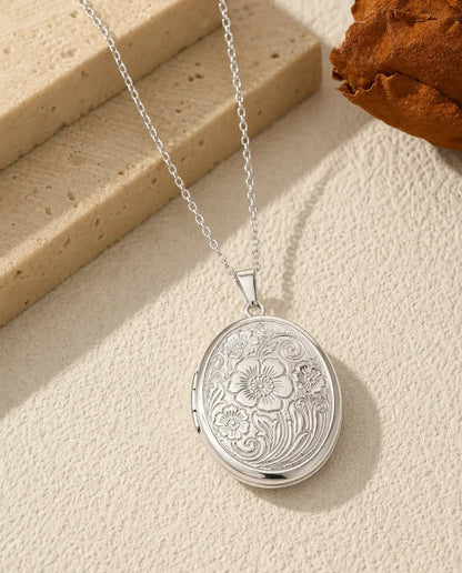 Oval photo locket necklace in polished silver with vintage wildflower engraving