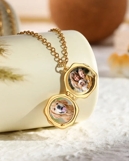 Paw print locket open showing two round photos of a dog and a family inside