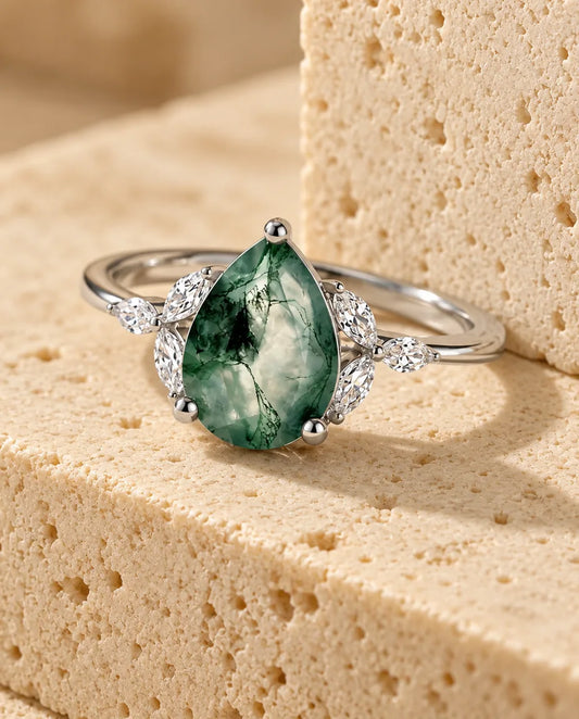 Moss Agate Engagement Ring - displayed on a travertine block