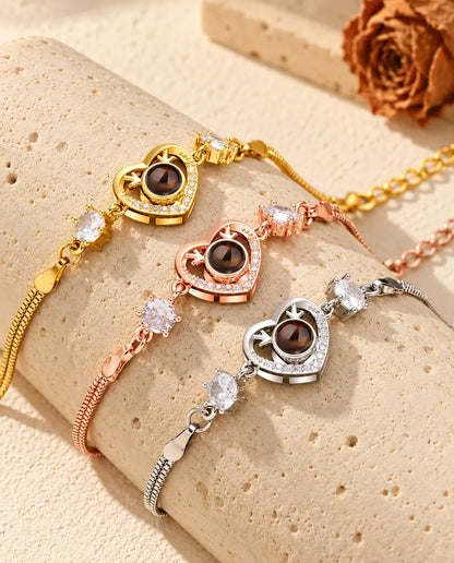 Three antler heart projection bracelets in gold tone, rose gold tone and silver tone draped over a travertine block