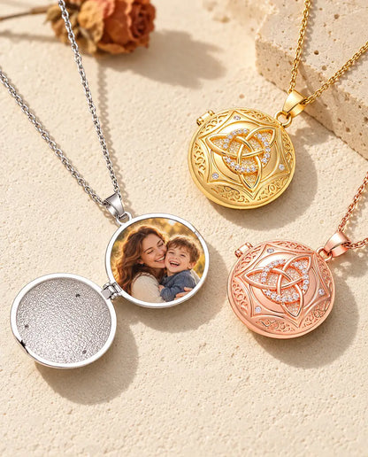 Silver Celtic knot locket opened to show a family photo inside, next to closed gold tone and rose gold tone lockets