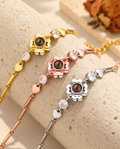 Three clover flower projection bracelets in gold tone, rose gold tone and silver tone over a travertine block