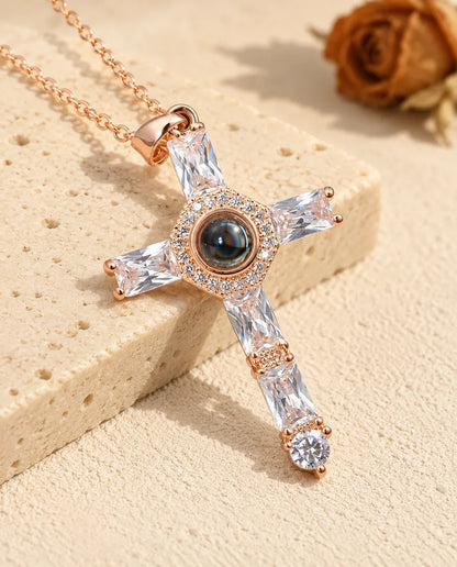Personalized rose gold tone cubic zirconia cross photo projection necklace beside travertine