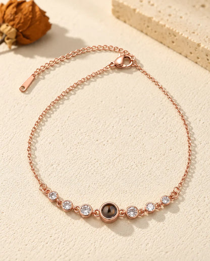 Rose gold tone photo projection bracelet with six bezel-set stones, lobster clasp and extender chain