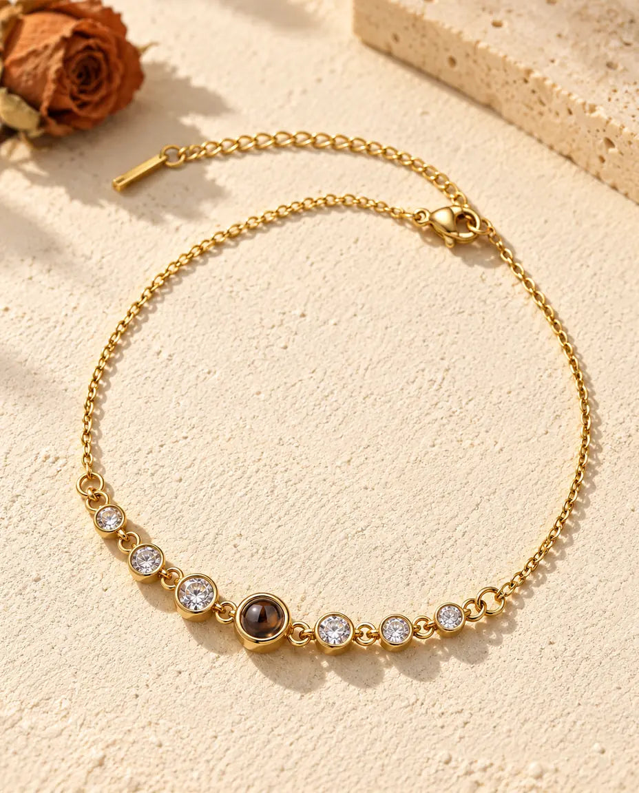 Gold tone stainless steel stone bracelet with a small brown projection stone at the center