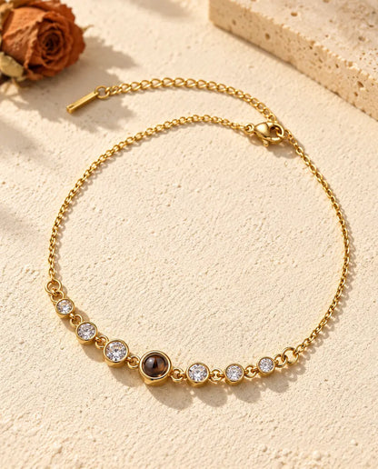 Gold tone stainless steel stone bracelet with a small brown projection stone at the center