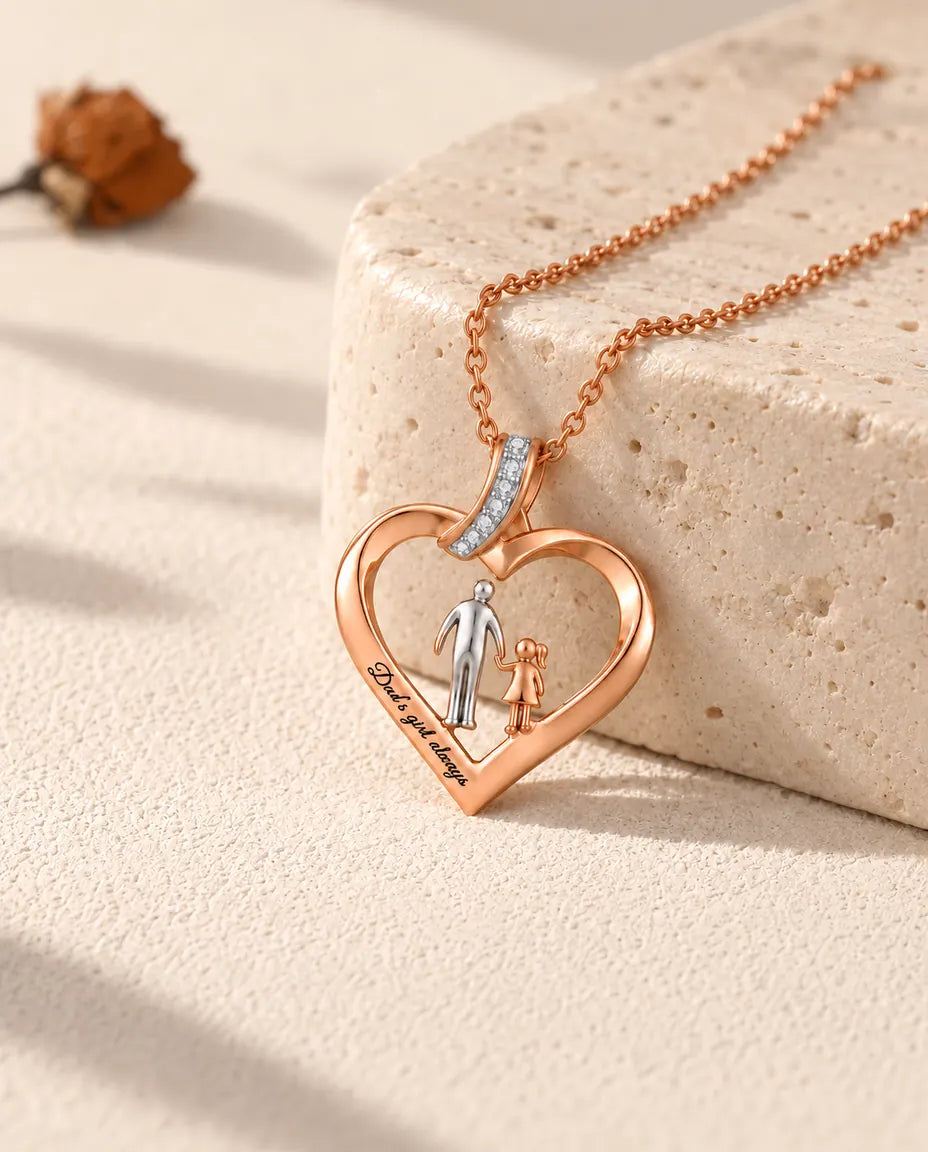 Personalized dad and daughter heart necklace in rose gold tone, resting against a travertine block