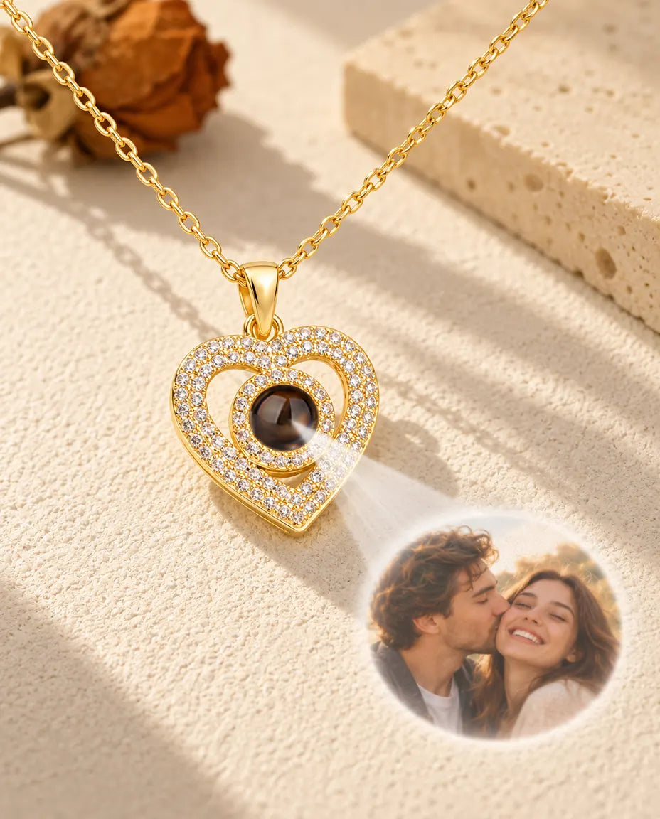 Light shining through the brown stone of the gold tone double heart pendant projects a photo of a couple