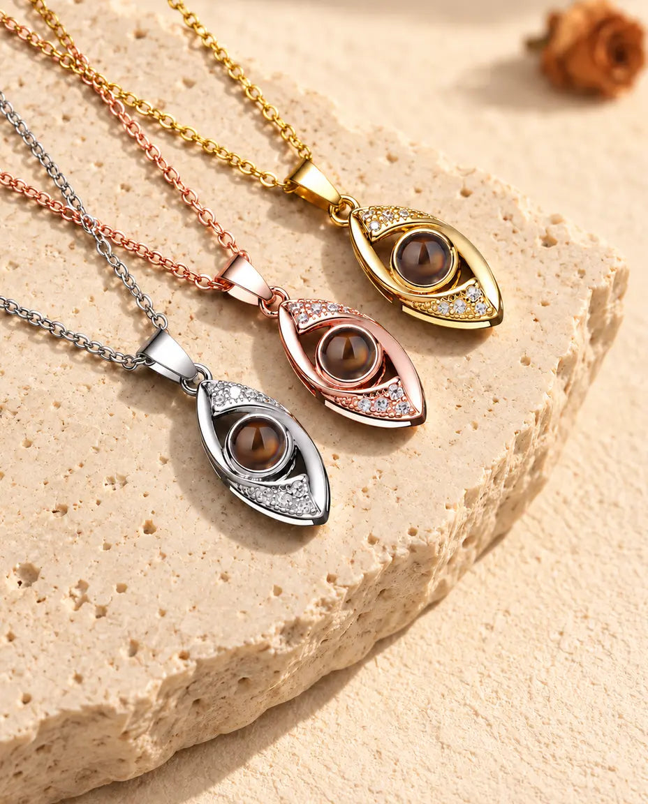 Evil eye projection necklaces in silver tone, gold tone and rose gold tone fanned out on travertine