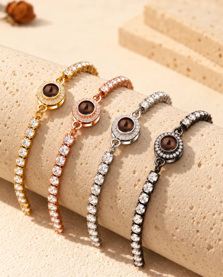Four photo projection tennis bracelets draped over a travertine block in each color