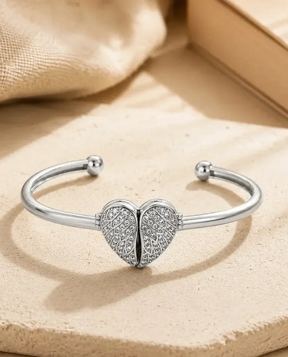 Silver cuff bangle with pave winged heart closed, flat lay